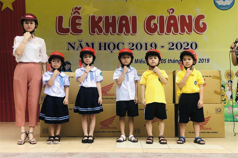 Hướng dẫn học sinh đội mũ bảo hiểm đúng cách khi ngồi trên xe gắn máy
