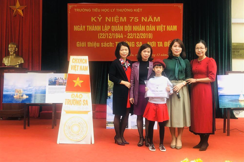 Cô giáo Phó Hiệu trưởng Đào Thanh Xuân và các cô giáo chụp ảnh lưu niệm với bạn Vũ Diễm Quỳnh - học sinh lớp 4A2 là con của chiến sỹ công tác tại biển đảo